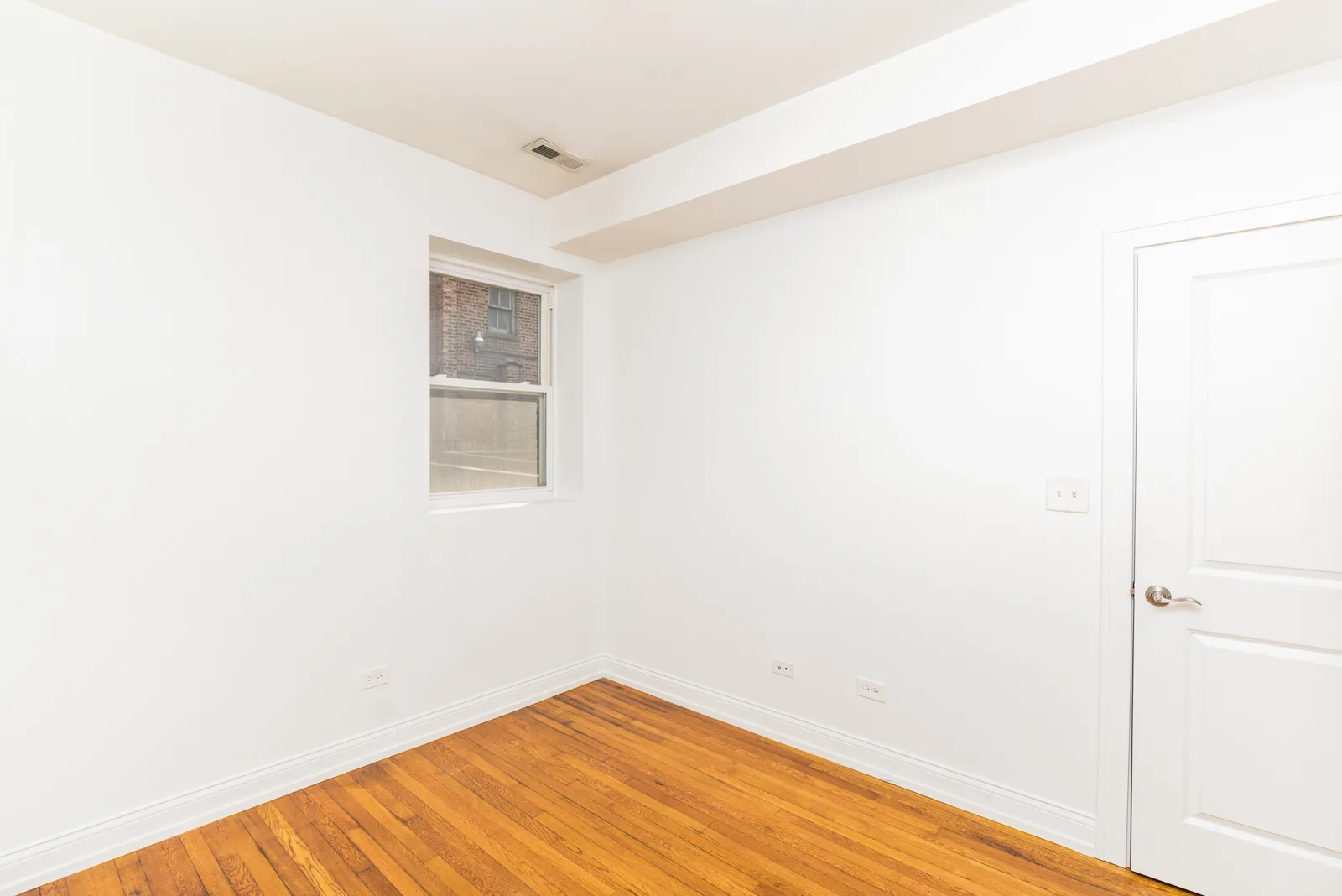 Bedroom with window and hardwood floors